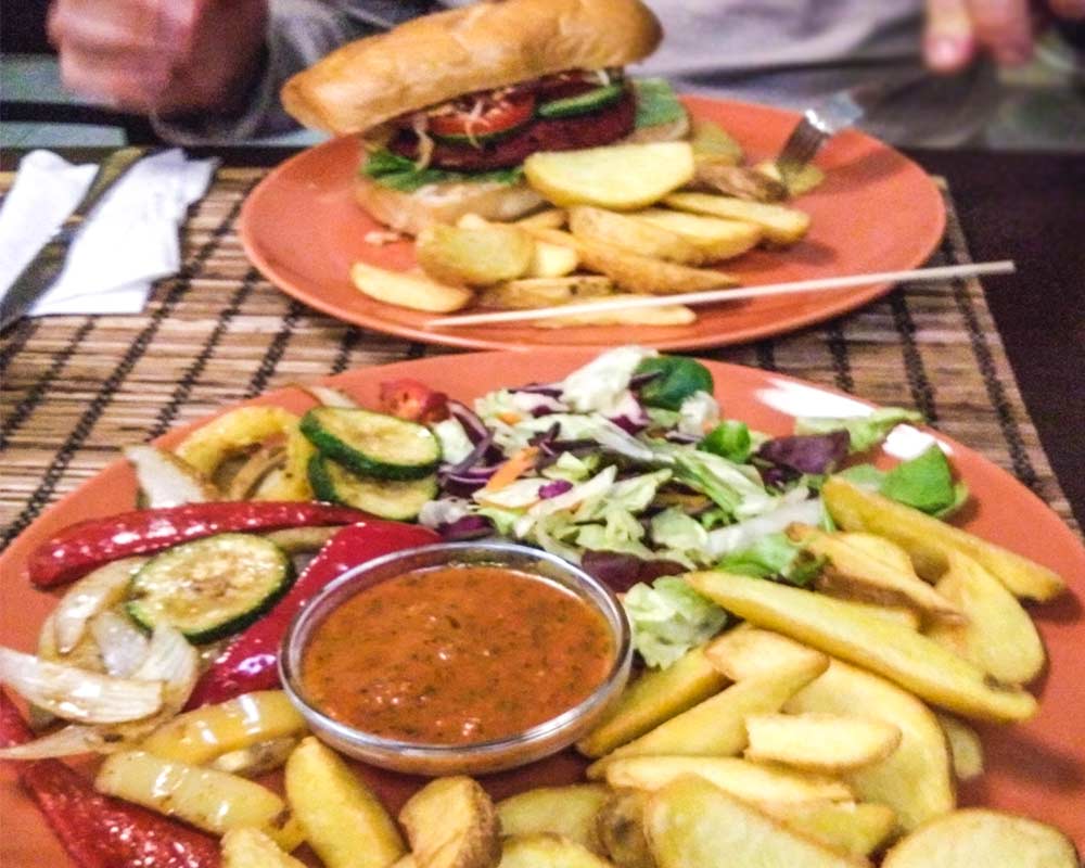 piatto misto con patatine fritte, insalata, verdure saltate e salsa budapest vegana e senza glutine