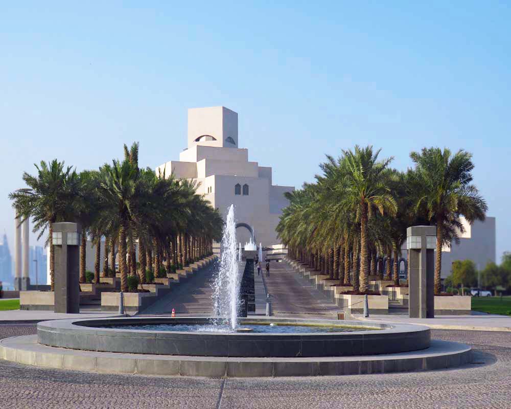 costruzione moderna del museo d'arte islamica con viale d'accesso fiancheggiato da palme