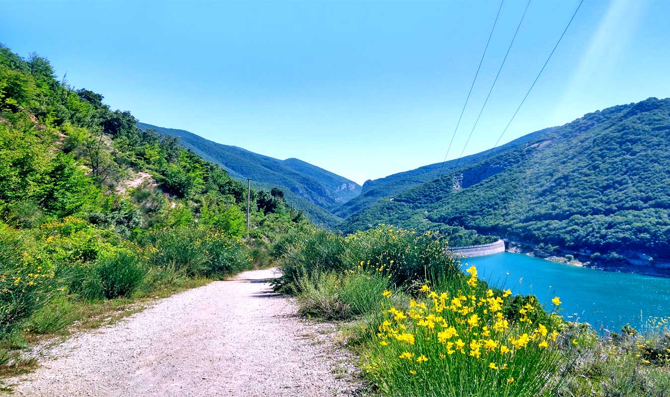sentiero lungo il lago di fiastra circondato dalle monatgne verso le lame rosse