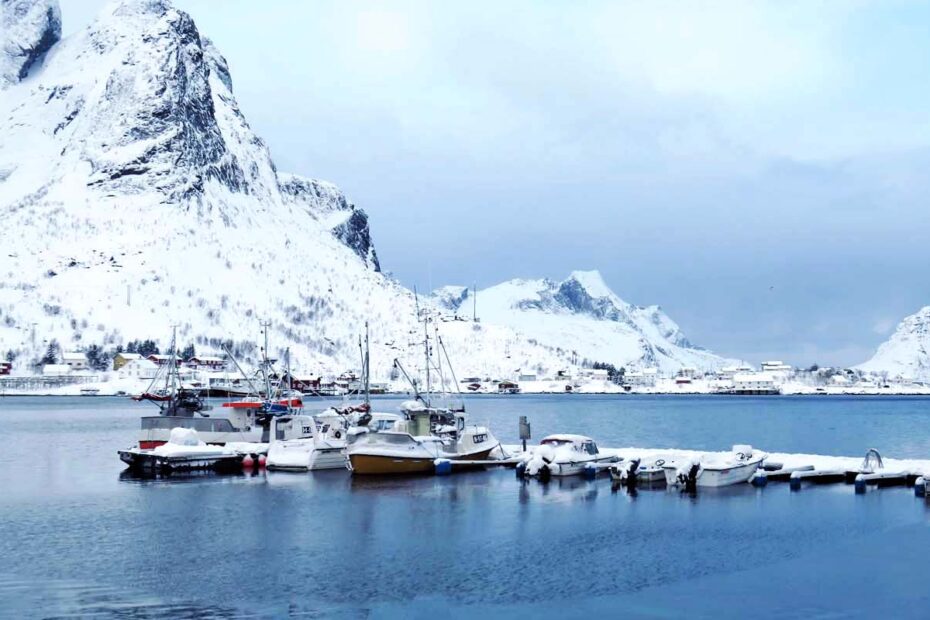 paesaggio con barche e montagne innevate sullo sfondo alle lofoten norvegia