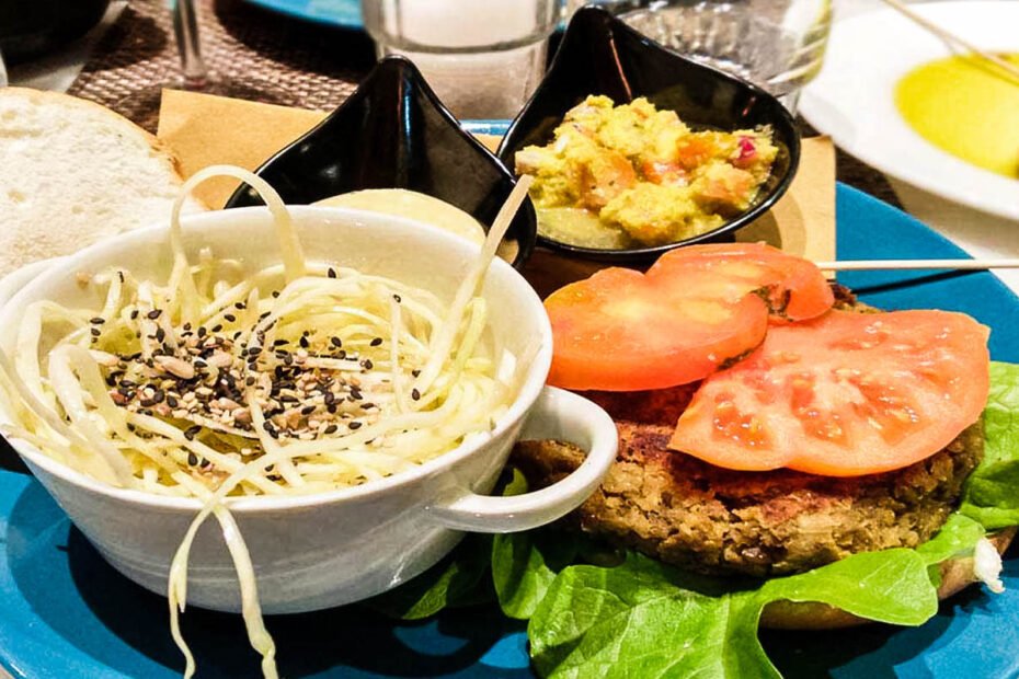 ciotola con insalata e burgher vegano accanto al ristorante quinoa