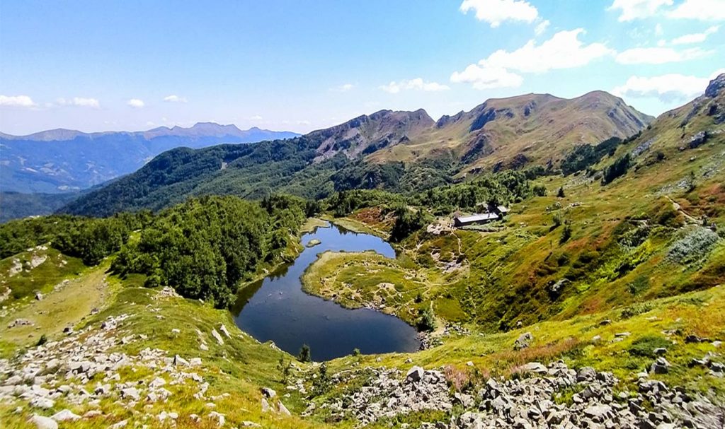 lago nero abetone circondato dalle montagne con il bivacco accanto