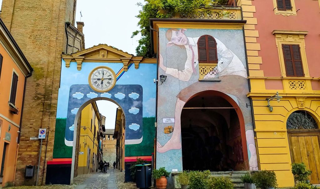 dozza murales sulla porta con orologio accanto alla torre e al municipio