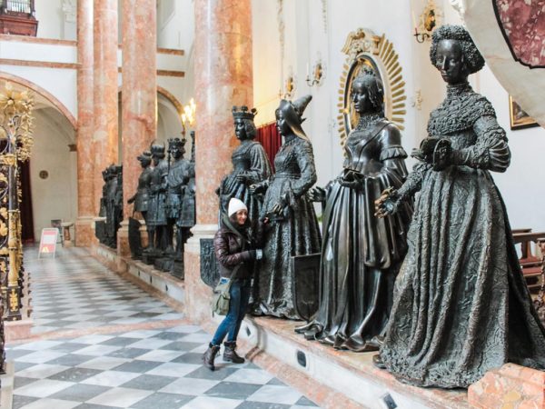persona accanto a statue bronzee all'interno della chiesa della corte innsbruck un giorno