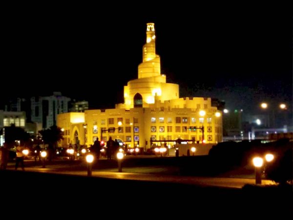 costruzione a spirale illuminata di notte che ospita il fanar qatar islamic center