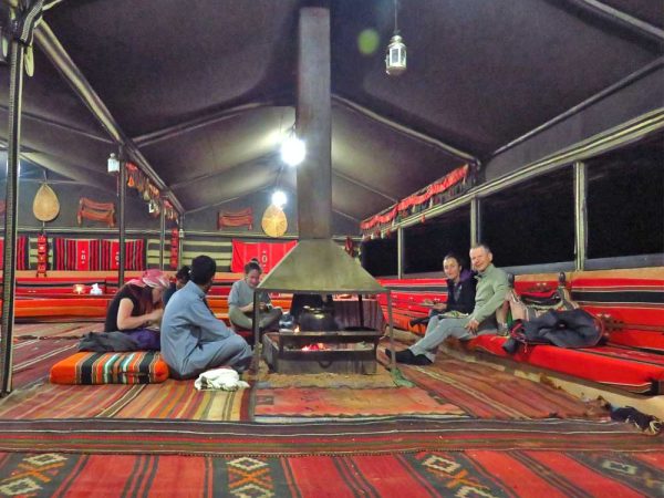 sette persone intorno al fuoco all'interno della tenda beduida a milky way camp a wadi rum