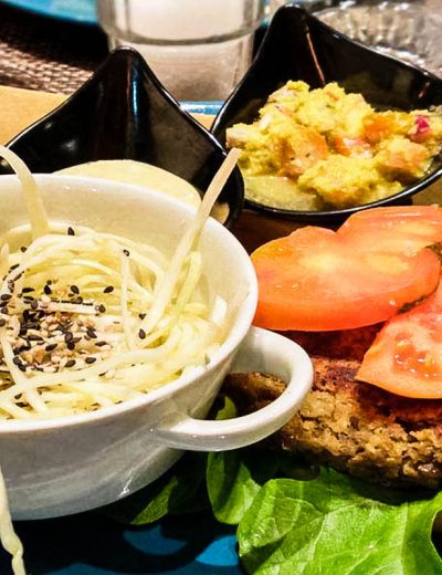 ciotola con insalata e burgher vegano accanto al ristorante quinoa